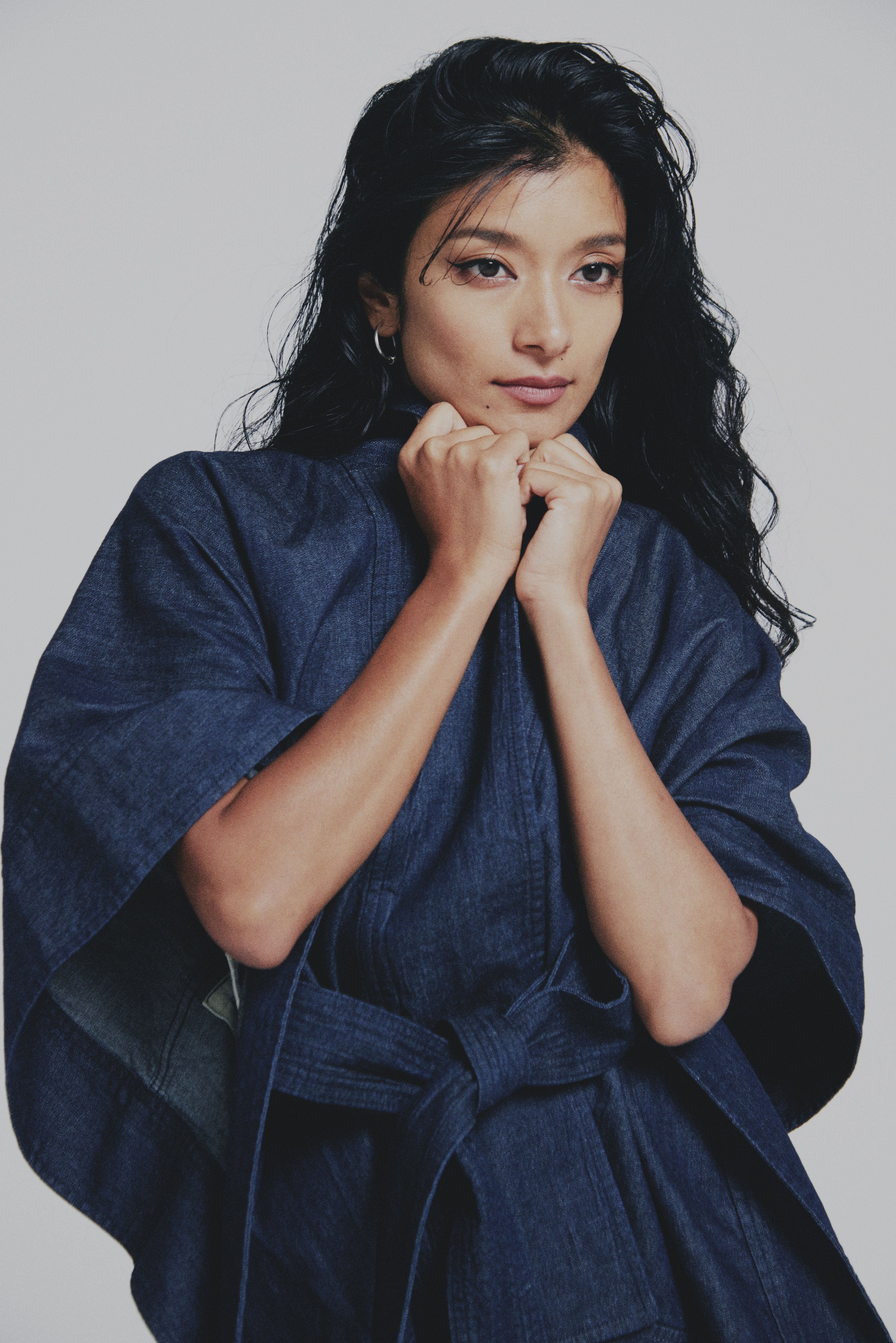 Woman wearing a blue kimono against a plain background